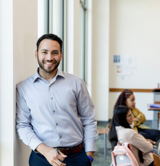 Professional student leaning against wall