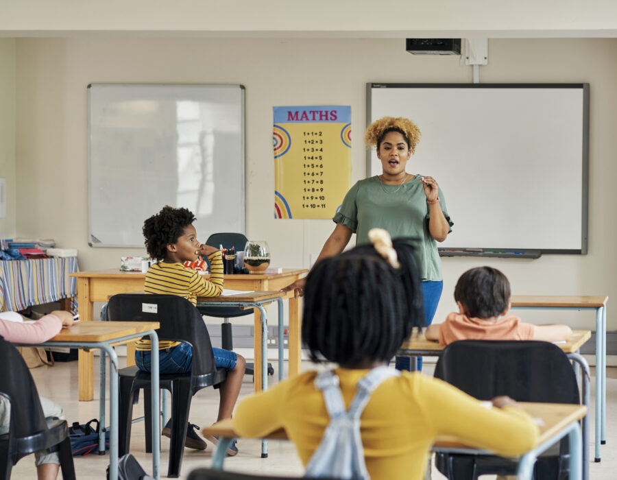 Photograph of a teacher leading a classroom discussion or lesson for elementary students.