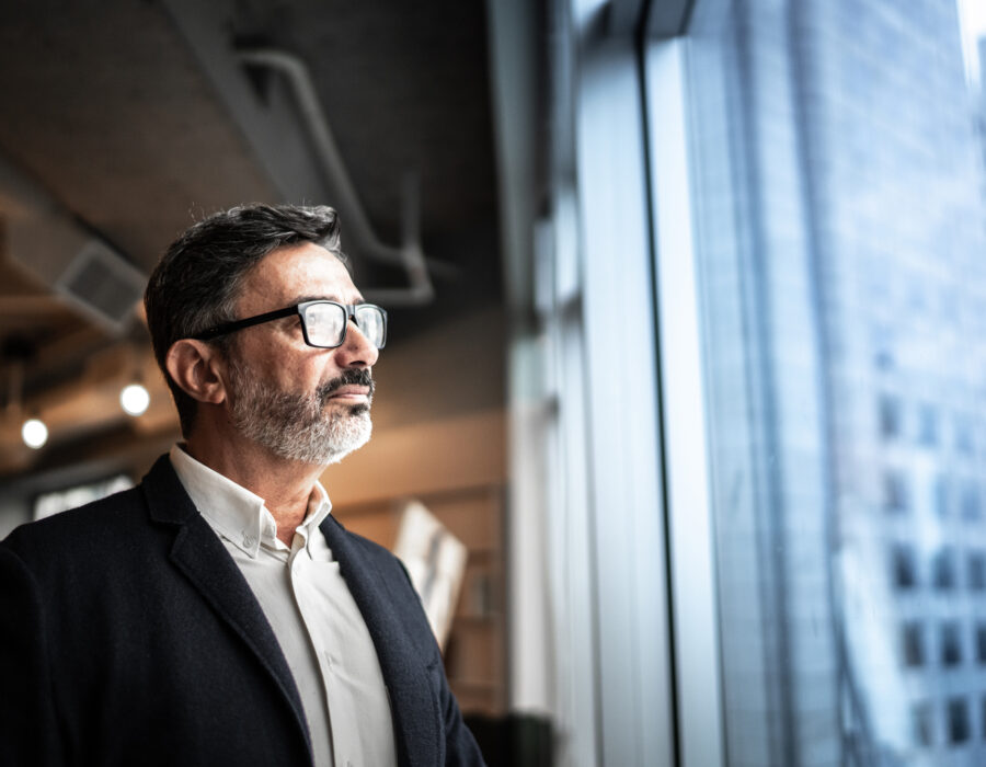 Mature businessman looking out of window pensively