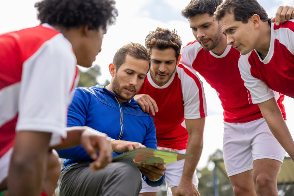 Soccer coach talking to his team about their strategy for the game