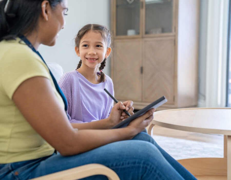 Woman counseling school-aged child in a school setting