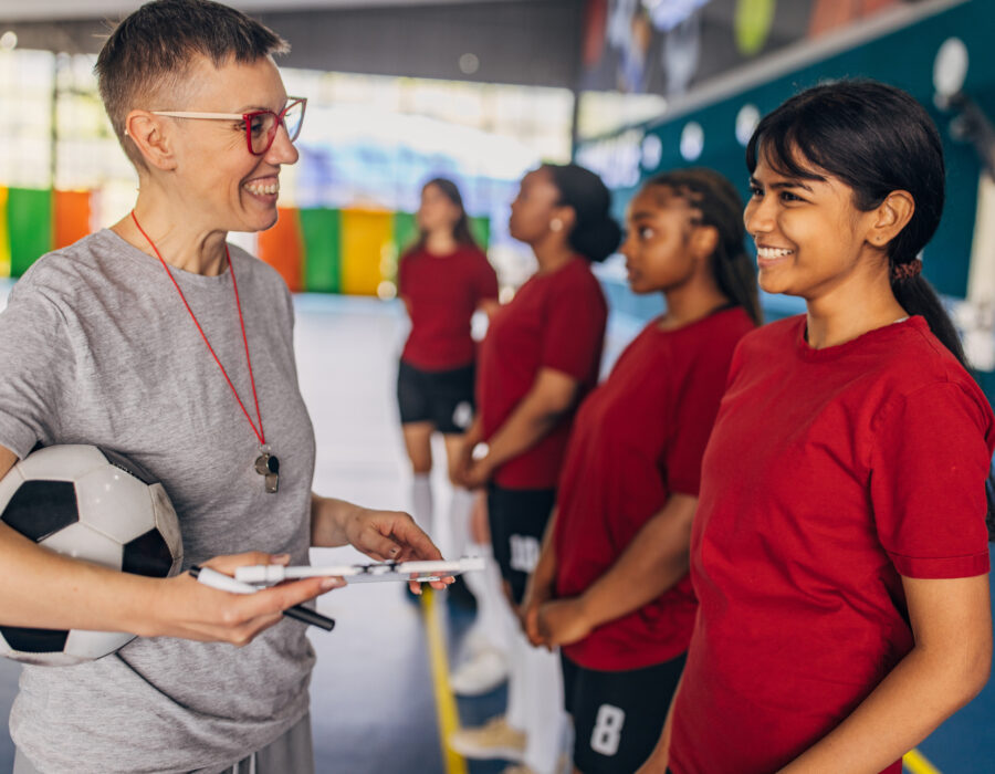 Coach and young soccer players interacting before a match or practice